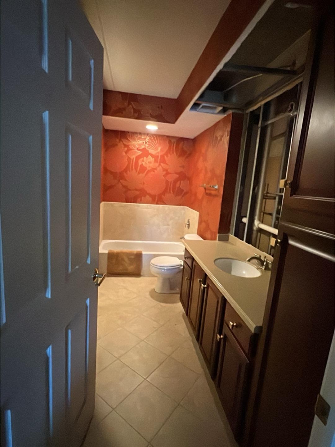 Condo bathroom in Lombard with the wall above the vanity opened to the framing after an upstairs leak