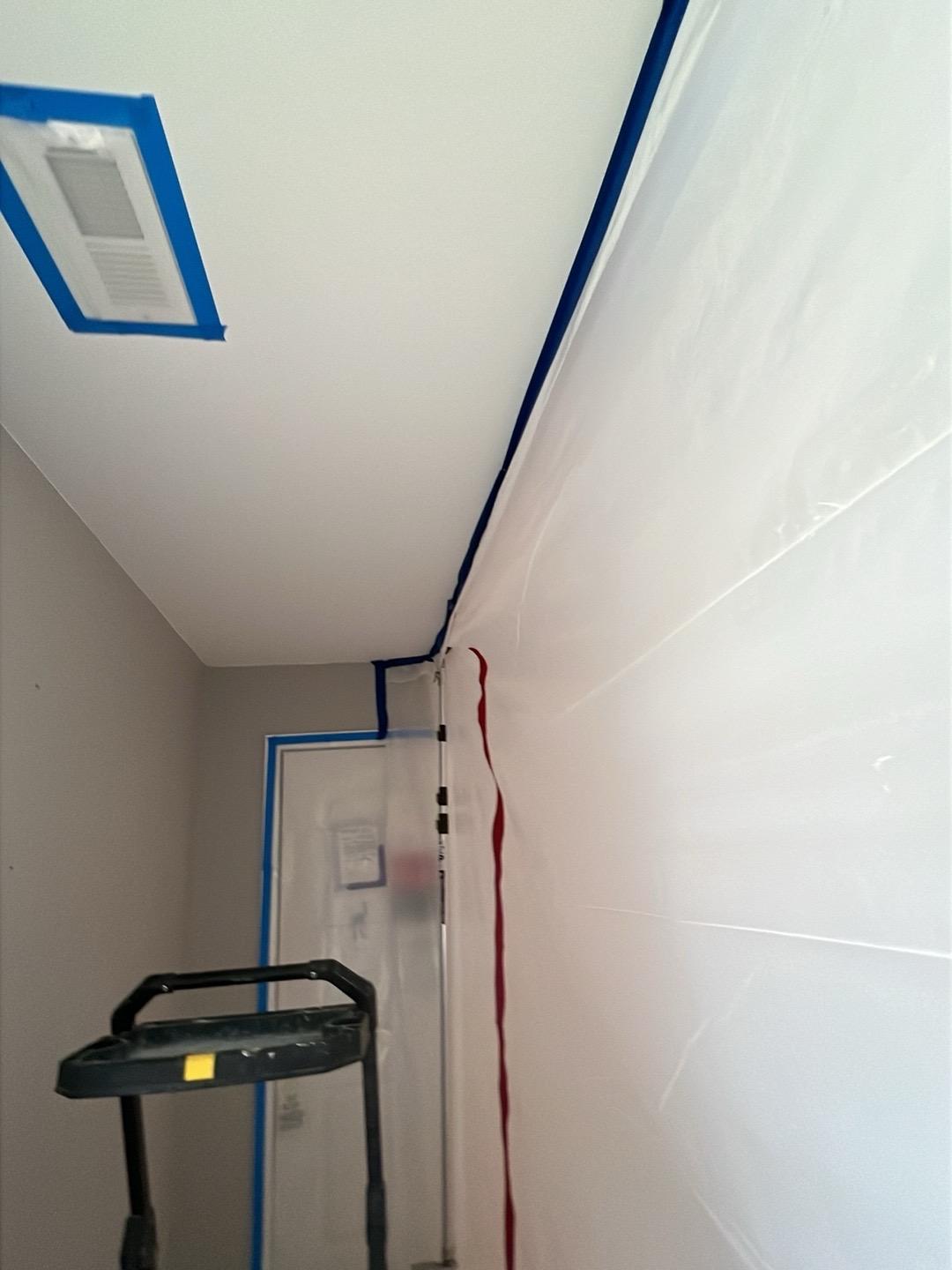 Plastic containment walls sealed with tape during water damage repairs in a Naperville home