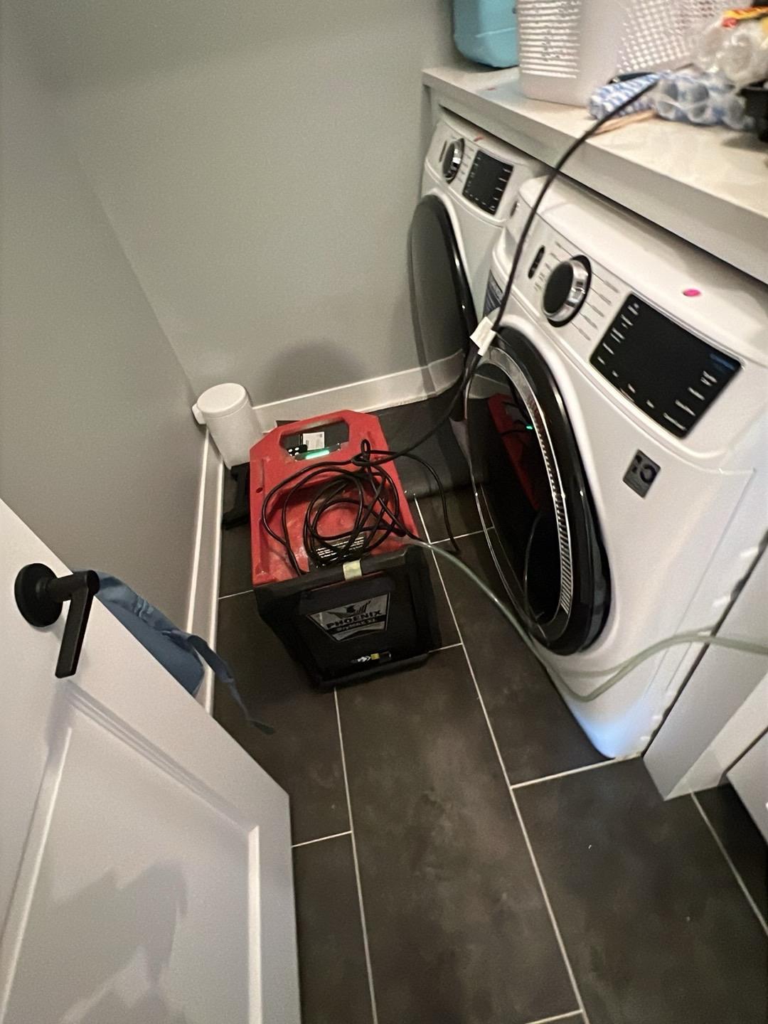 Air mover drying the laundry room floor of a Downers Grove home