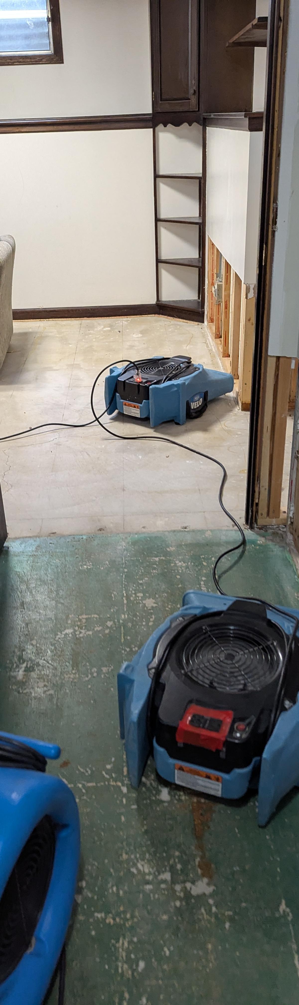 Basement with flood cuts opened to the studs and an air mover drying the room in a Lisle home