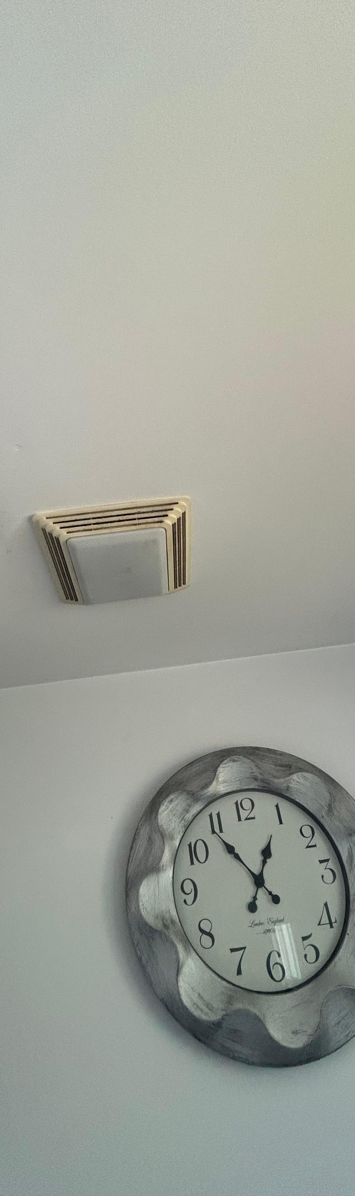 Mold spots on a bathroom wall next to the exhaust fan in an Aurora home