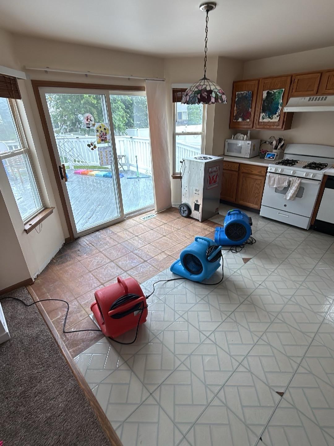 Air movers and a dehumidifier drying a Naperville kitchen after water damage