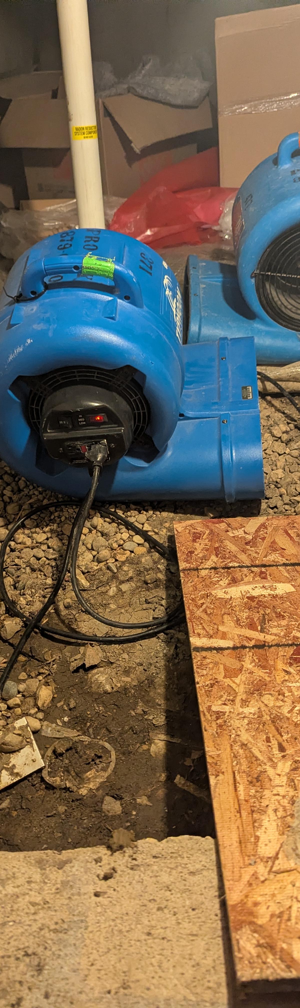 Two air movers drying a gravel crawl space floor in a Wheaton home