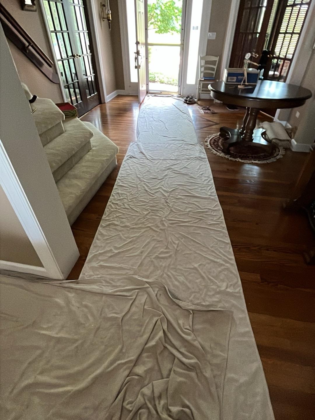 Protective floor runners covering the entryway of an Aurora home during water damage restoration