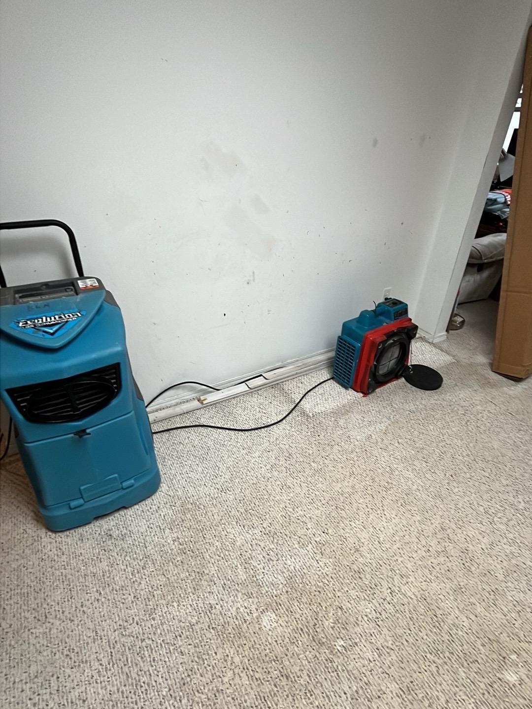 Dehumidifier and air scrubber drying a carpeted basement room in a Bolingbrook home